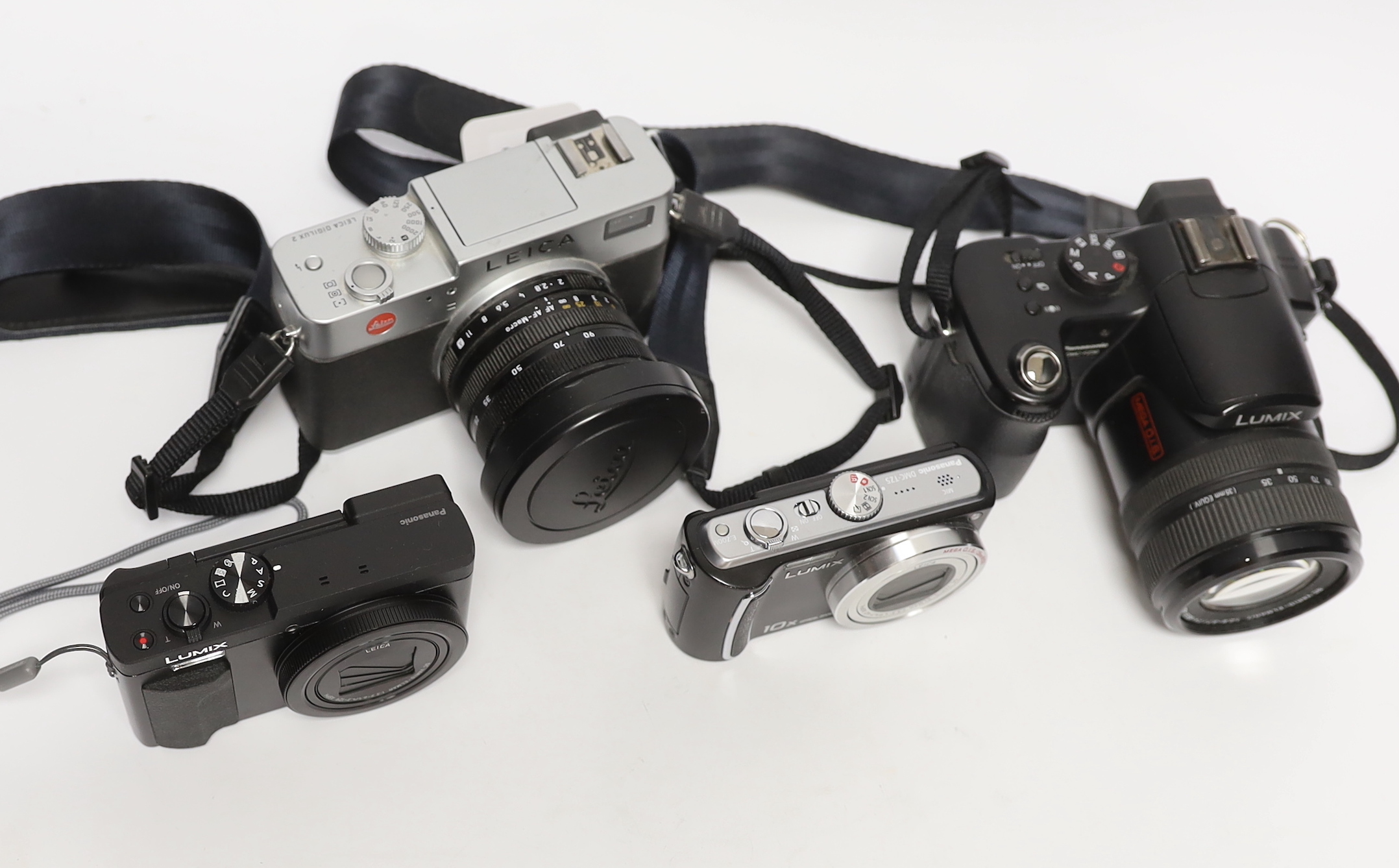 Four digital cameras; a Leica Digilux 2 and three Panasonic Leica models from the LUMIX series